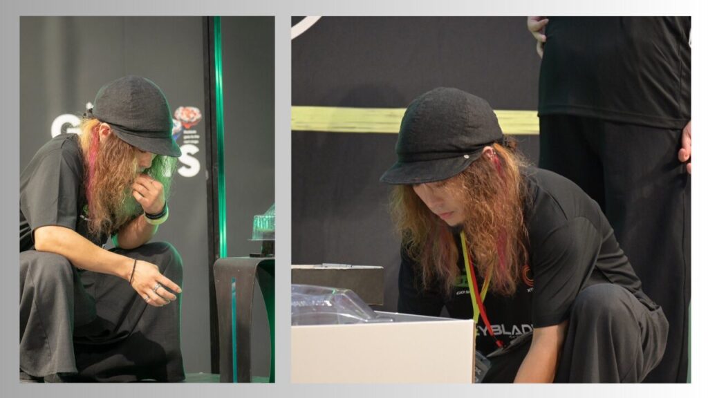 試合中に考え込むMokky選手の様子(ステージ上でしゃがみ込み、次の一手を整理している場面)