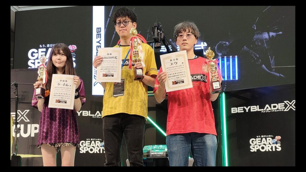 BEYBLADE XのG1グランプリで1位〜3位の選手がトロフィーと賞状を手に記念撮影する様子
