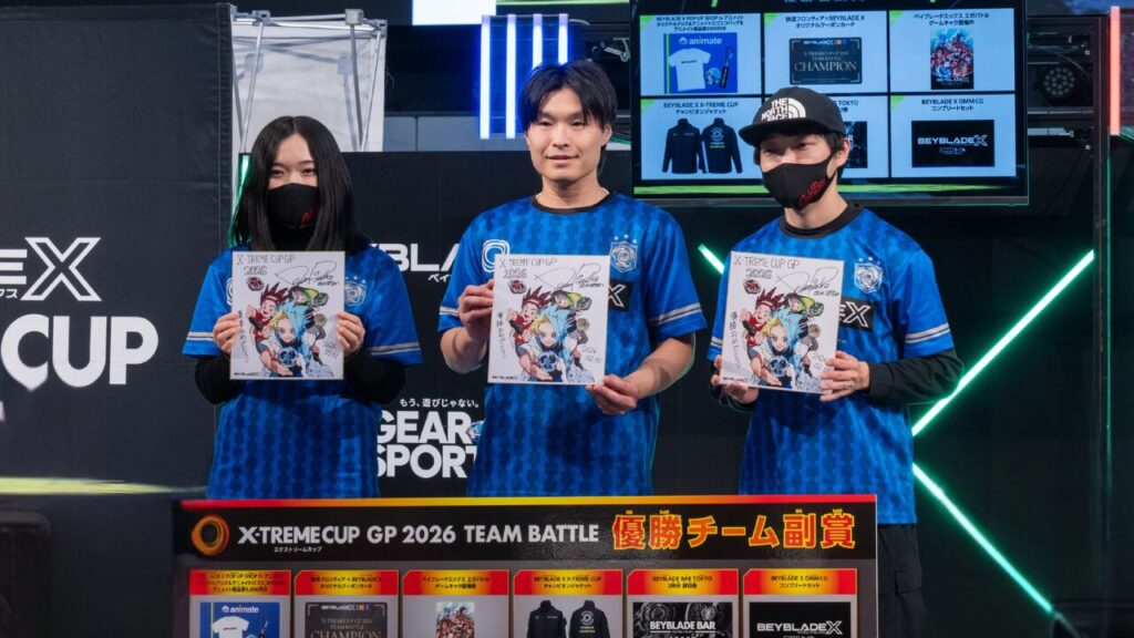 XTREME CUP GP2026 TEAM BATTLEの表彰で、Go for Beyの3人が副賞のサイン色紙を手に記念撮影する様子
