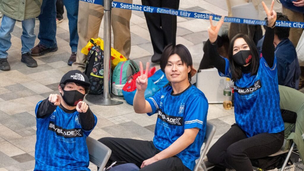 会場の客席でGo for Beyの3人がピースサインで応える様子